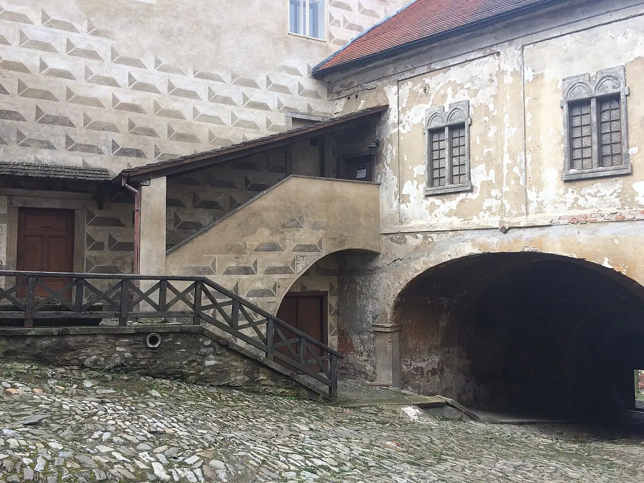 Nádvoří ledečského hradu se sgrafitovou fasádou a dřevěným schodištěm