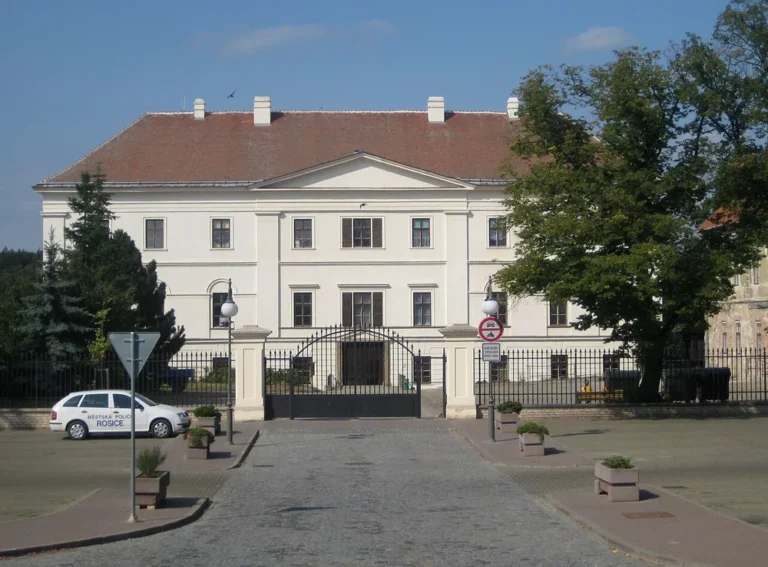 Východní průčelí zámku Rosice s trojúhelníkovým štítem za bránou a městskou ulicí