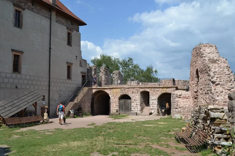 Nádvoří hradu Pecka s opraveným palácem a torzy kamenných hradeb