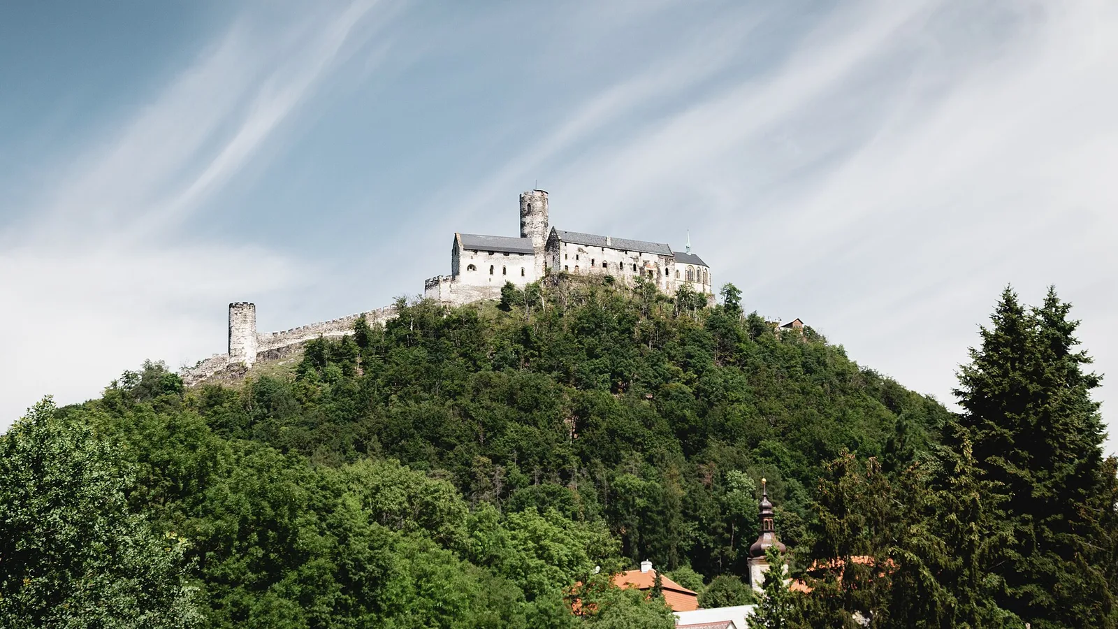 Hrad Bezděz na zalesněném vrchu nad obcí