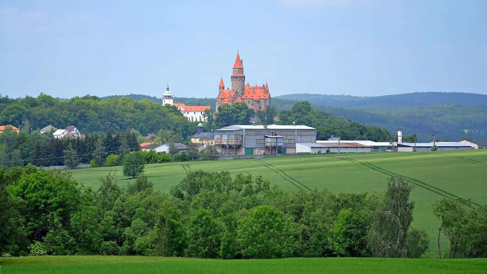 Hrad Bouzov nad lesy a poli při pohledu z dálky