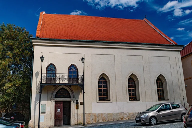 Synagoga maior v Boskovicích s červenou střechou a řadou oken v průčelí.