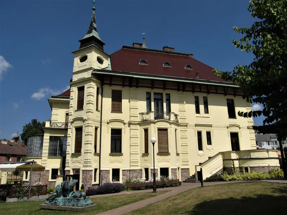Hernychova vila v Ústí nad Orlicí při pohledu ze zahrady, s věží a zdobenou fasádou.