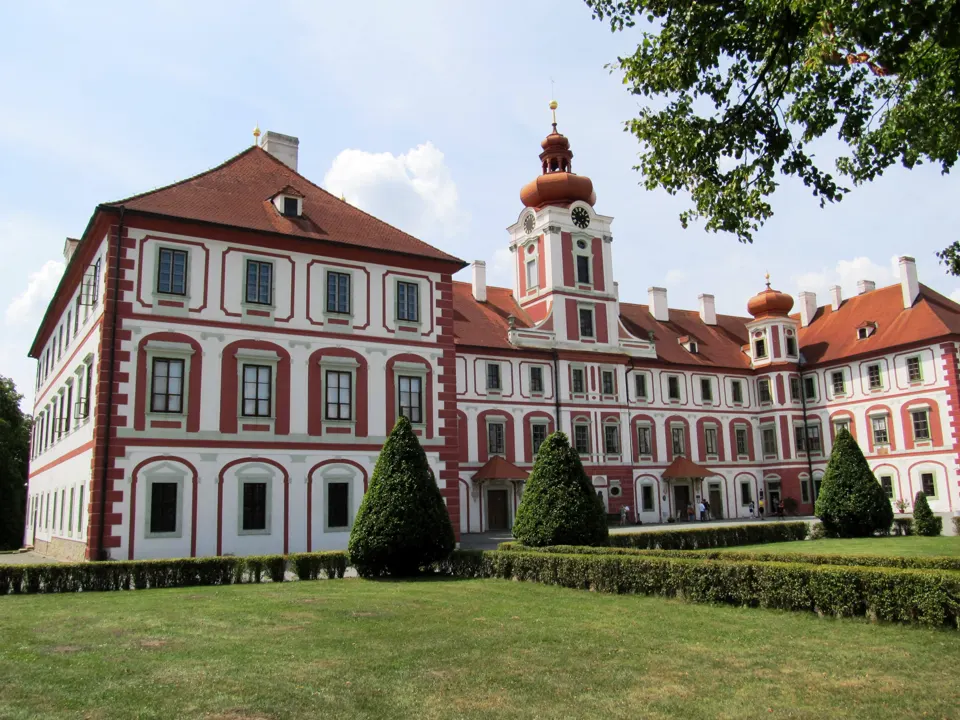 Červenobílé průčelí zámku Mnichovo Hradiště při pohledu ze zahrady