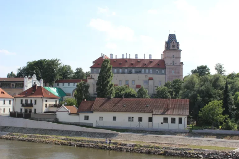 Zámek Brandýs nad Labem při pohledu od řeky s věží a červenými střechami