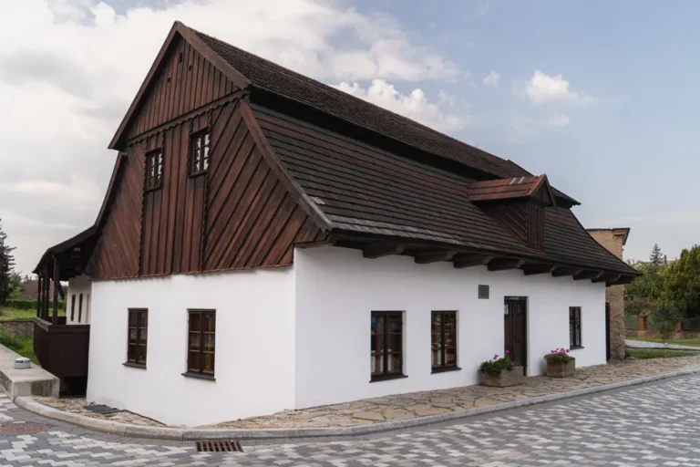 Rodný domek Františka Vladislava Heka v Dobrušce s bílou omítkou a dřevěným štítem