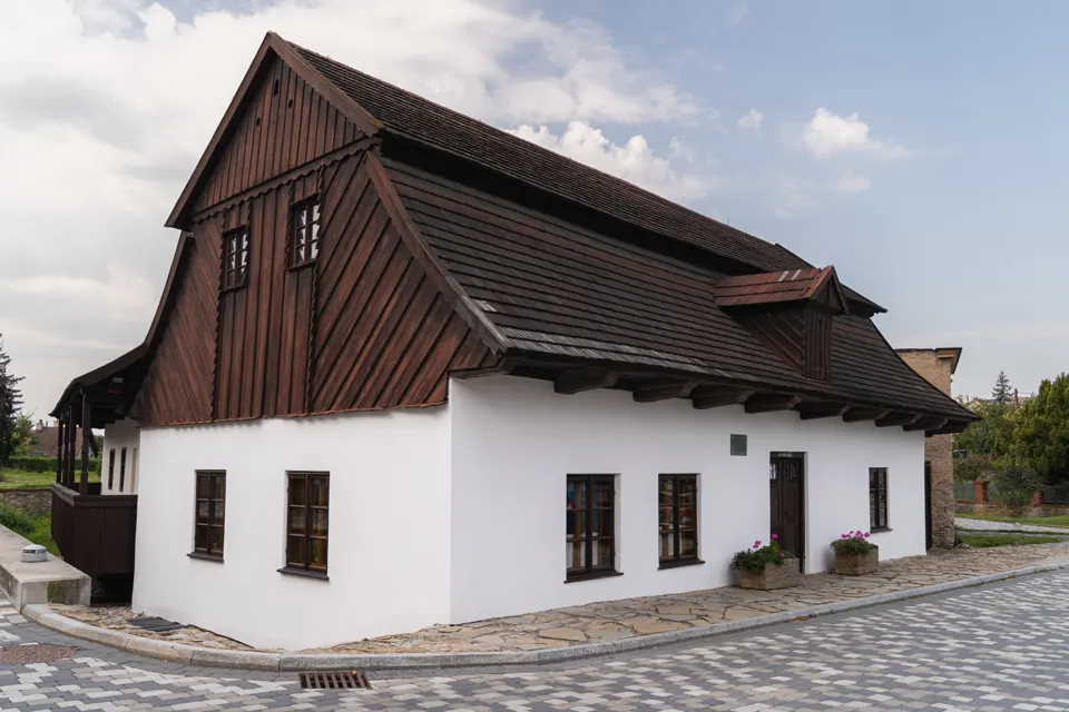 Rodný domek Františka Vladislava Heka v Dobrušce s bílou omítkou a dřevěným štítem