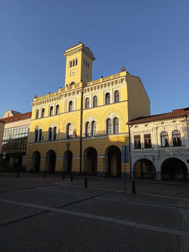 Žlutá radnice s věží na náměstí Míru ve Frenštátu pod Radhoštěm
