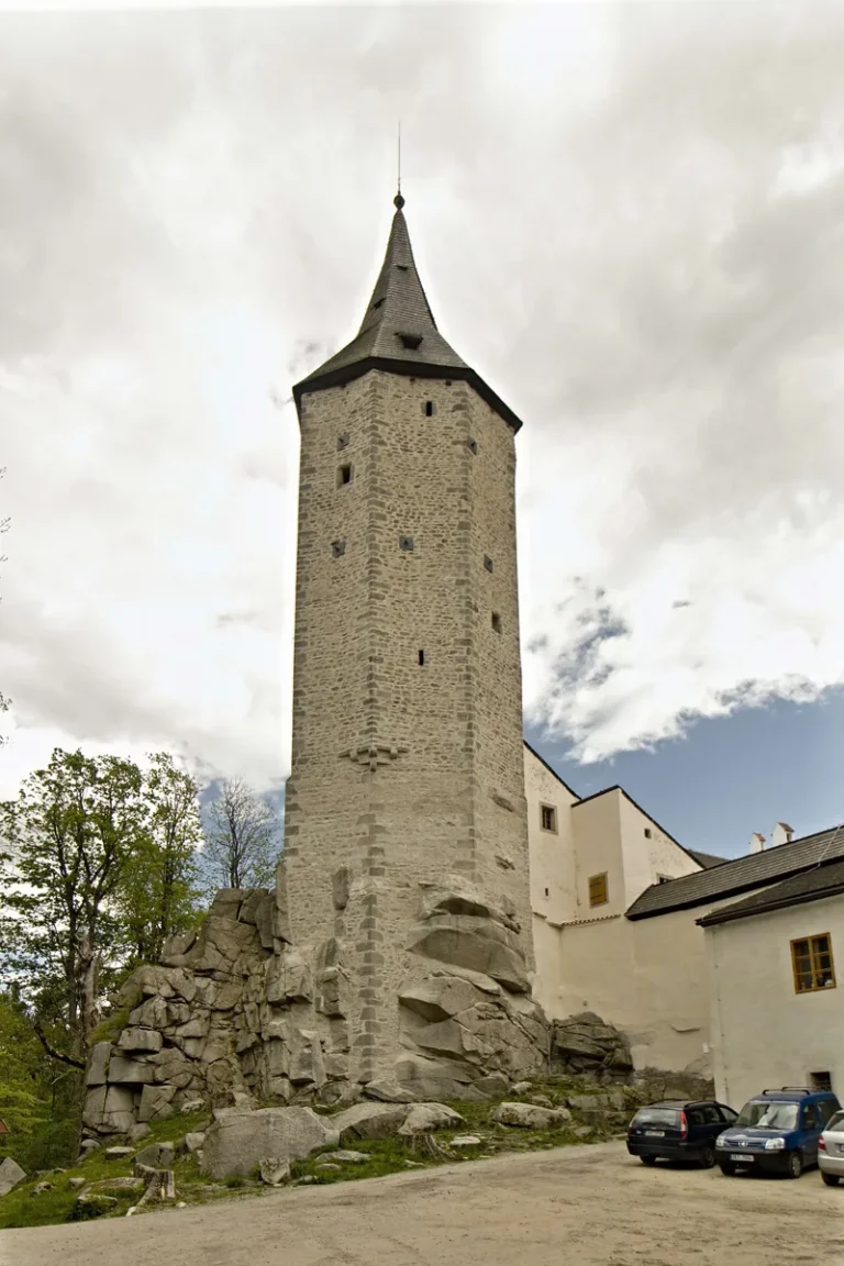 Kamenná věž hradu Roštejn nad skalním podložím na archivní fotografii