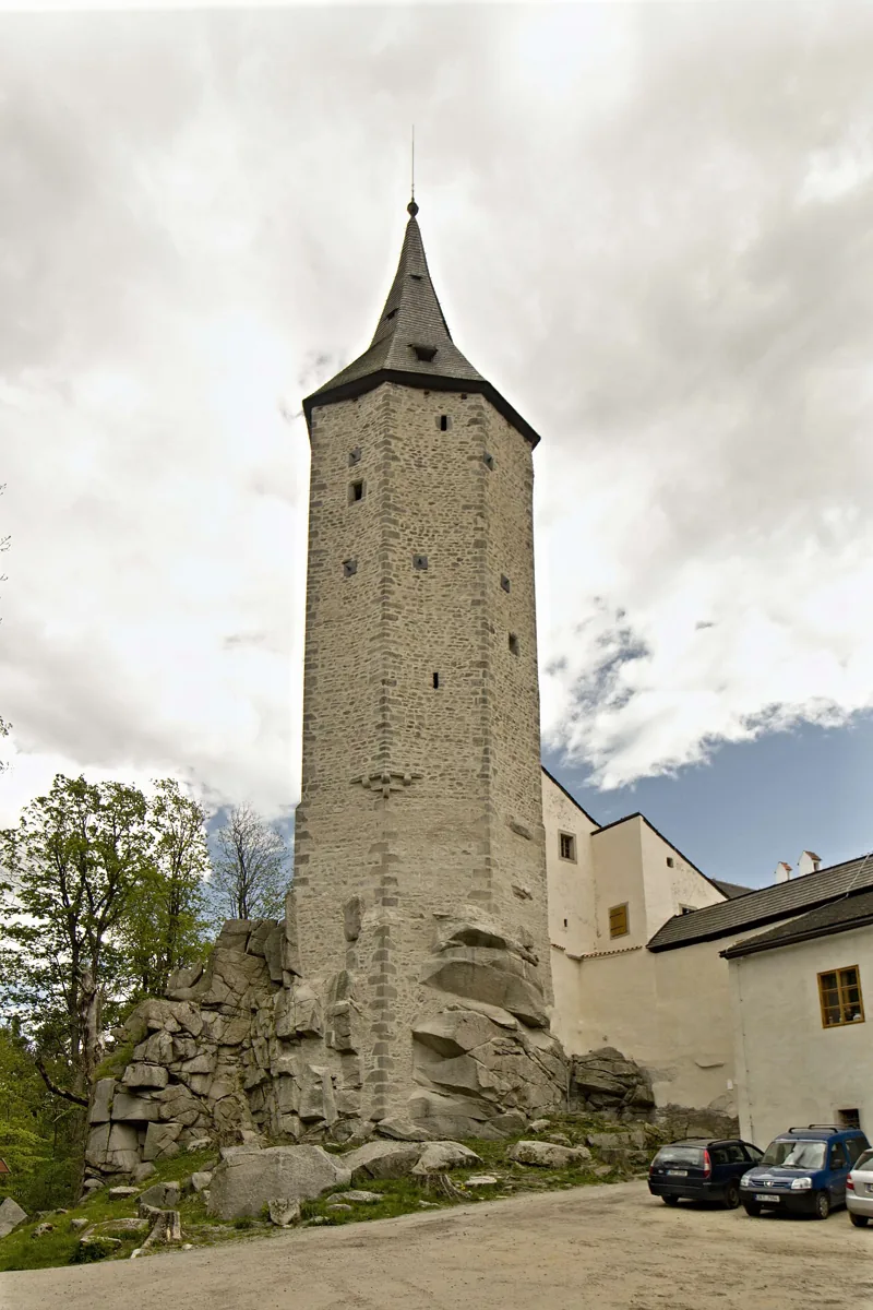 Kamenná věž hradu Roštejn nad skalním podložím na archivní fotografii