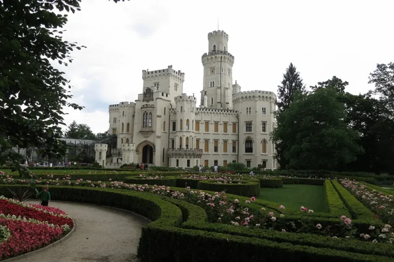 Zámek Hluboká nad Vltavou s věží a upravenou květinovou zahradou